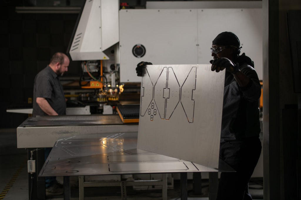 two men working in the machine shop to create control room equipment pieces.