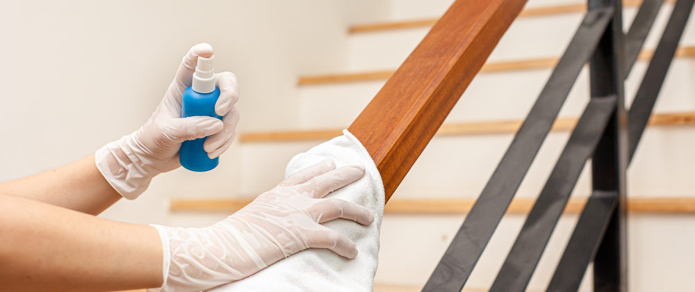 close up of hands cleaning the railing in a control center stair way