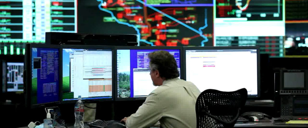 A control center specialist sits on control room furniture.